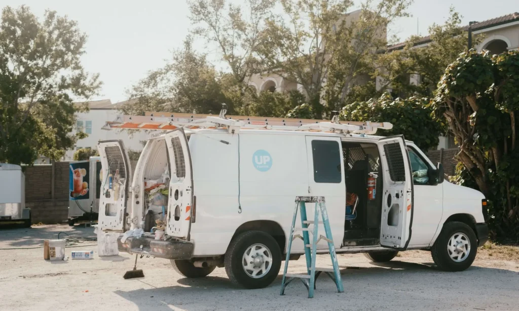 Branded Sarasota exterior painters van parked at a painting job site.